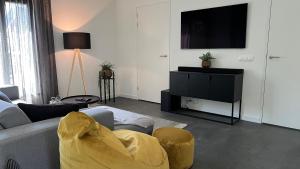 un salon avec un canapé et une télévision dans l'établissement VILLA ARYVE in See-, Strand- und Golfplatznähe inklusive NETFLIX, Bad en Suite und Wohlfühlgarantie, à Dirkshorn 44 autres photos