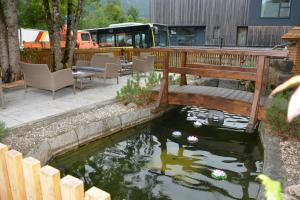 a pond in a yard with a wooden deck and a bench at Happy Point Apartment in Mellau