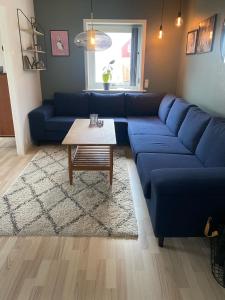 a blue couch in a living room with a coffee table at Cosy house in the old village in Miðvágur