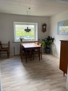 Miðvágur的住宿－Cosy house in the old village，一间带桌子和窗户的用餐室
