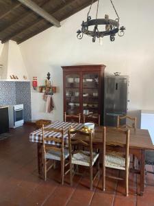 a dining room with a wooden table and chairs at Monte da Samarra in Avis