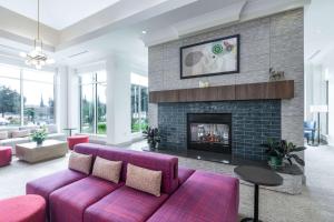 sala de estar con sofá púrpura y chimenea en Hilton Garden Inn Gilroy, en Gilroy