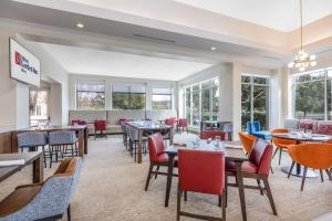 a restaurant with tables and chairs and windows at Hilton Garden Inn Gilroy in Gilroy