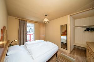 Un dormitorio con una cama blanca y una ventana. en Ciasa Buro - Zen, en Moena