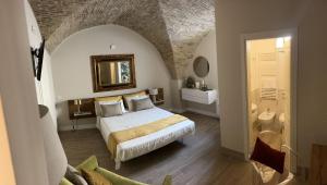 a bedroom with a bed and a bathroom with a mirror at La Fabbrica di San Pietro Vasto in Vasto