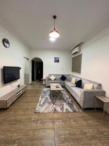 uma sala de estar com um sofá e uma televisão de ecrã plano em شقق الفتح الخاصة Al-Fateh Private Apartments em Al Madinah