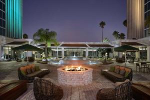 a patio with a fire pit and chairs and a building at DoubleTree by Hilton at the Entrance to Universal Orlando in Orlando