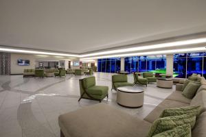 a lobby with couches and chairs and windows at DoubleTree by Hilton at the Entrance to Universal Orlando in Orlando