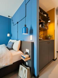 ein Schlafzimmer mit einem Bett und einer blauen Wand in der Unterkunft Nena Apartments Bochum City in Bochum