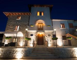 ein Gebäude mit einer Treppe, die nachts zu einer Tür führt in der Unterkunft Agriturismo U' Casinu dà Scala in Campora San Giovanni