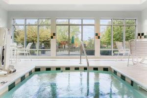 una piscina in una casa con finestre di Hilton Garden Inn Cleveland/Twinsburg a Twinsburg