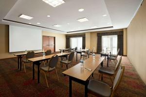 einen Konferenzraum mit Tischen, Stühlen und einem Whiteboard in der Unterkunft Hilton Garden Inn Houston/The Woodlands in The Woodlands
