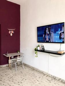 een woonkamer met een tv aan de muur bij LOFT 82 in Mérida