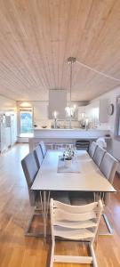comedor con mesa y sillas y cocina en Holiday home close to forest, lake and skiing en Ulricehamn