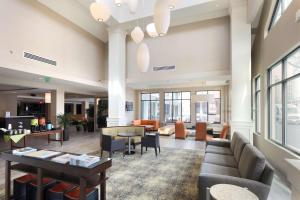 a lobby with a couch and tables and chairs at Hilton Garden Inn Reagan National Airport in Arlington