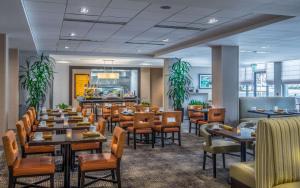 a restaurant with tables and chairs and a bar at Hilton Garden Inn Reagan National Airport in Arlington