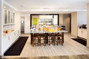 a kitchen with a large dining room table with chairs at Hilton Garden Inn Reagan National Airport in Arlington