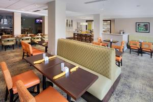 a restaurant with tables and chairs and a bar at Hilton Garden Inn Reagan National Airport in Arlington