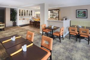 a restaurant with tables and chairs and a kitchen at Hilton Garden Inn Reagan National Airport in Arlington