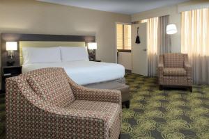 a hotel room with a bed and a chair at Hilton Garden Inn Reagan National Airport in Arlington