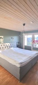 un grande letto in una camera da letto con soffitto in legno di Holiday home close to forest, lake and skiing a Ulricehamn