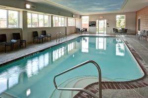 ein großer Pool in einem Hotel mit Stühlen und Tischen in der Unterkunft Hampton Inn & Suites Texarkana in Texarkana - Texas