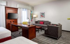 Habitación de hotel con escritorio y sofá en Hampton Inn & Suites Texarkana, en Texarkana