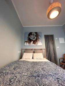 Un dormitorio con una cama y una foto de una mujer en Pearl of the sea en H̱adera