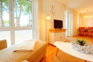 a living room with a couch and a tv at Bernsteinquartier Ferienwohnung Blaues Fenster in Kölpinsee