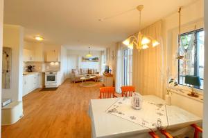 a kitchen and living room with a table and chairs at Bernsteinquartier Ferienwohnung Blaues Fenster in Kölpinsee