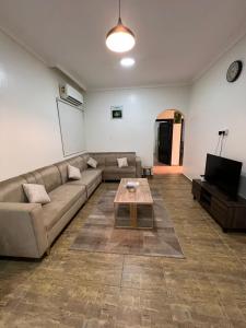 شقق الفتح الخاصة Al-Fateh Private Apartments في المدينة المنورة: غرفة معيشة مع أريكة وطاولة قهوة