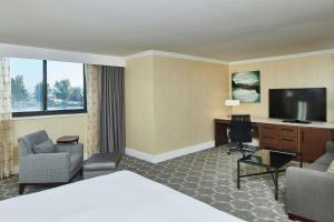 a hotel room with a bed and a flat screen tv at DoubleTree by Hilton Hotel Salt Lake City Airport in Salt Lake City