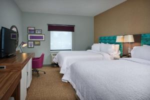 a hotel room with two beds and a flat screen tv at Hampton Inn Sherwood Portland in Sherwood