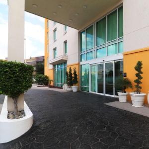 un bâtiment avec des plantes en pot devant lui dans l'établissement Hampton by Hilton Reynosa Zona Industrial, à Reynosa