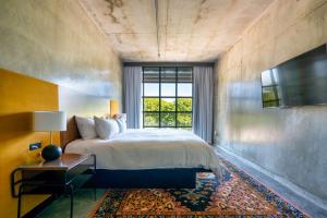 a bedroom with a large bed and a window at NYLO Providence Warwick Hotel, Tapestry Collection by Hilton in Warwick