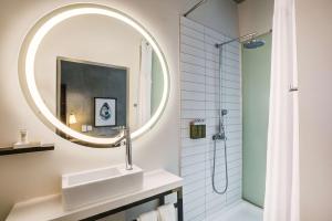 NYLO Providence Warwick Hotel, Tapestry Collection by Hilton في وارويك: حمام مع حوض ومرآة