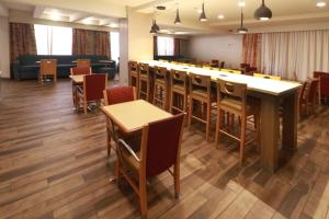 a dining room with a bar and tables and chairs at Hampton by Hilton Chihuahua in Chihuahua