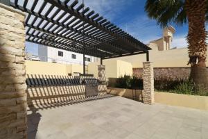 a patio with a black pergola in front of a building at Hampton by Hilton Chihuahua in Chihuahua