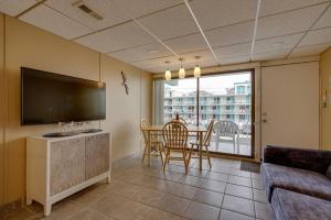 a living room with a television and a table with chairs at Cozy Oceanfront Condo with Pool and Beach Access! in Wildwood Crest
