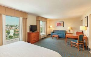 a hotel room with a bed and a desk and a television at Hampton by Hilton Queretaro Tecnologico in Querétaro