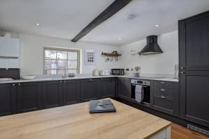 a kitchen with black cabinets and a wooden counter top at Paradise Square - Remodelled 18th Century Apartme in Sheffield