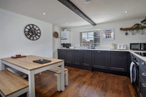 a kitchen with black cabinets and a wooden table at Paradise Square - Remodelled 18th Century Apartme in Sheffield