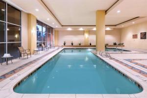 Embassy Suites by Hilton Albuquerque في ألباكيركي: حمام سباحة في غرفة الفندق مع ماء أزرق في فندق
