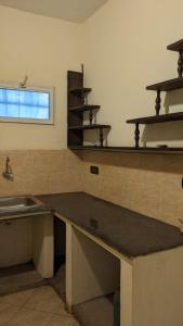 une cuisine avec un comptoir, un évier et des étagères dans l'établissement AR Sun Hotel, à Diego Suarez