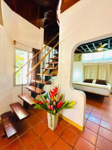a room with a staircase and a vase of flowers at Hotel Luna Llena in Tamarindo