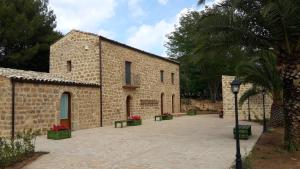 un edificio de ladrillo con un patio delante de él en La Quercia e l'Asino, en Piazza Armerina