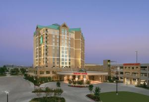 弗赖拉辛Embassy Suites by Hilton Dallas Frisco Hotel & Convention Center的一座大楼，前面有一个停车场