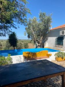 a yellow couch sitting next to a pool at Monte da Samarra in Avis