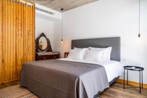 a bedroom with a large bed and a mirror at Casa Da Avo Clementina Nº32 in Funchal