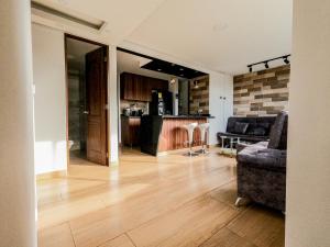 a living room with a couch and a kitchen at Apartamento cerca al aeropuerto in Rionegro